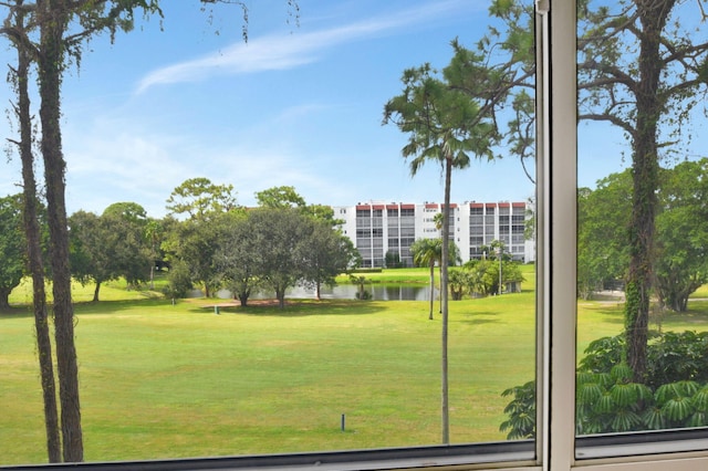 view of home's community with a water view and a lawn