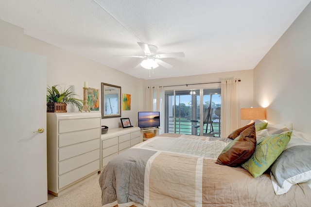 bedroom featuring a textured ceiling, ceiling fan, access to exterior, and light carpet