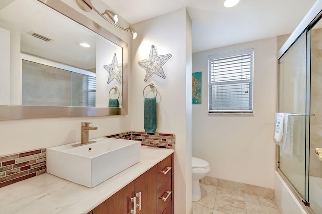 full bathroom with tasteful backsplash, enclosed tub / shower combo, tile patterned floors, toilet, and vanity