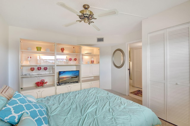 bedroom featuring ceiling fan, a closet, and light colored carpet