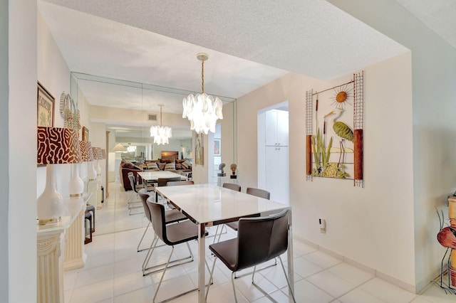 tiled dining space with a chandelier and a textured ceiling