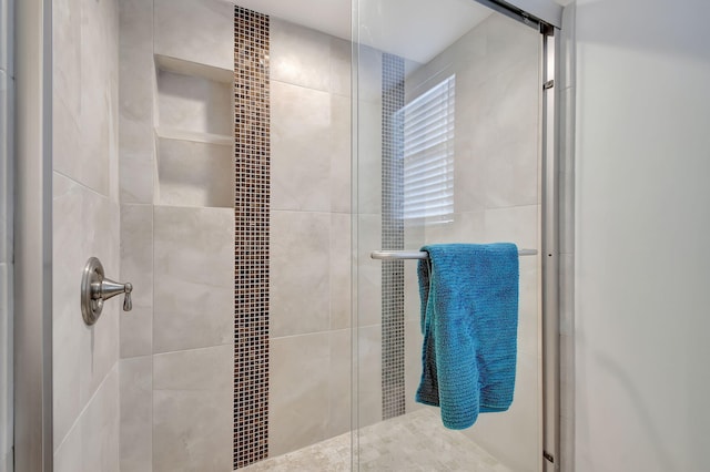 bathroom featuring a shower with door