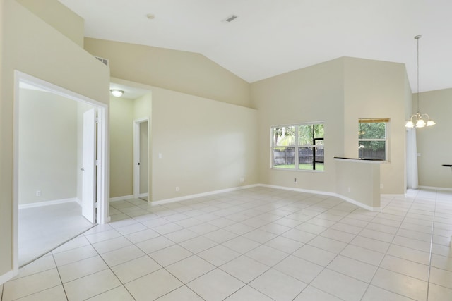 spare room featuring a notable chandelier, light tile patterned floors, and high vaulted ceiling