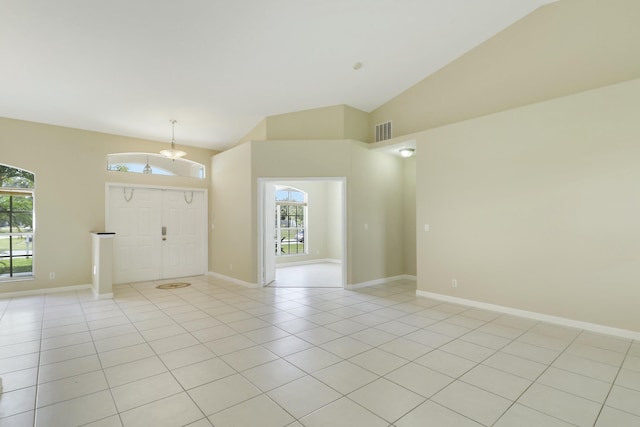 entrance foyer with light tile patterned floors, high vaulted ceiling, and an inviting chandelier