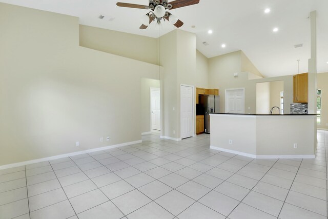 interior space featuring ceiling fan, high vaulted ceiling, and light tile patterned flooring