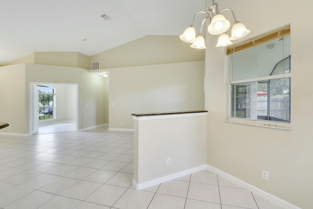 spare room featuring light tile patterned floors, a chandelier, and vaulted ceiling