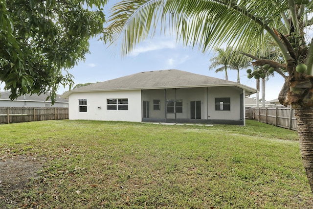 back of property with a sunroom and a yard