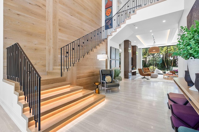 staircase with wooden walls and a high ceiling