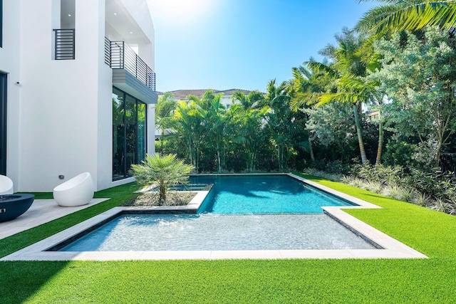 view of swimming pool featuring a yard