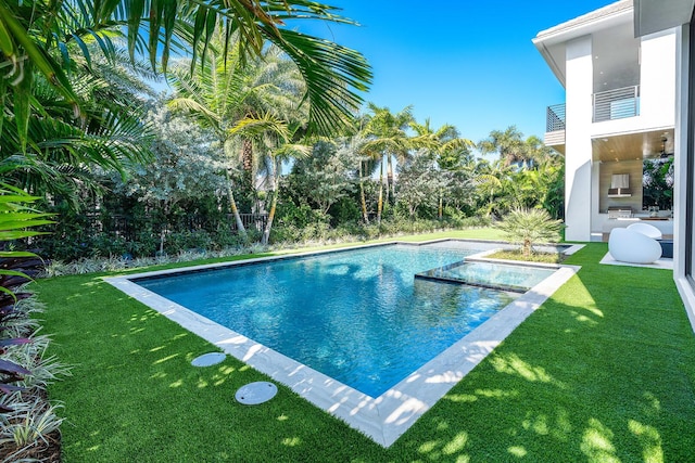 view of pool featuring a yard and an outdoor fireplace