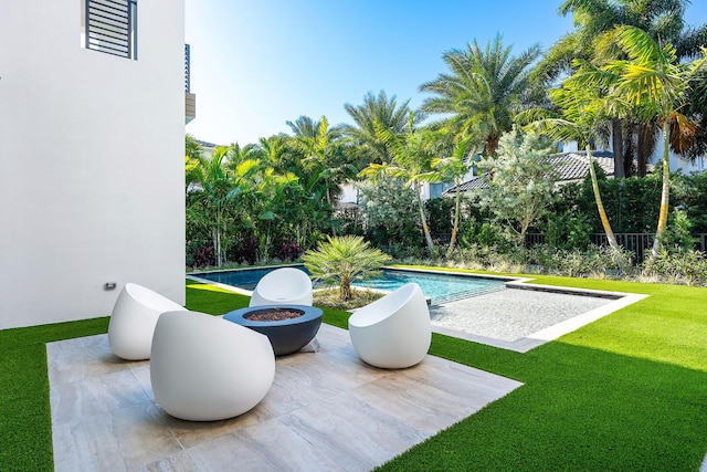 view of swimming pool featuring a yard and an outdoor fire pit