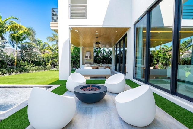 view of patio with a fire pit and ceiling fan