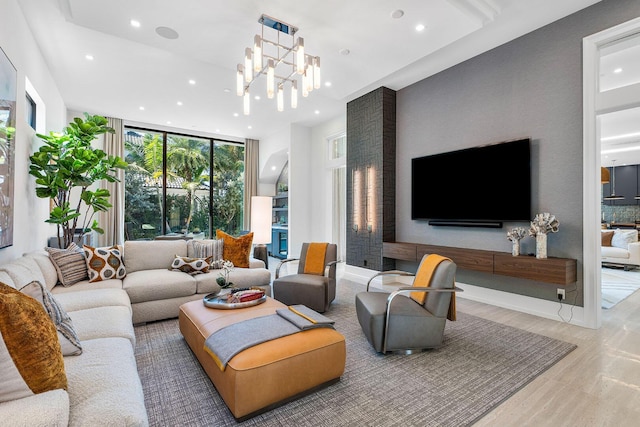 living room featuring a chandelier, light hardwood / wood-style flooring, and a wall of windows