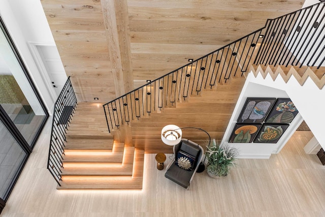 stairway featuring wood ceiling, wood-type flooring, and a towering ceiling