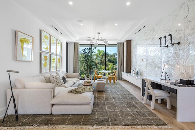 living room featuring a chandelier, a tray ceiling, and dark wood-type flooring