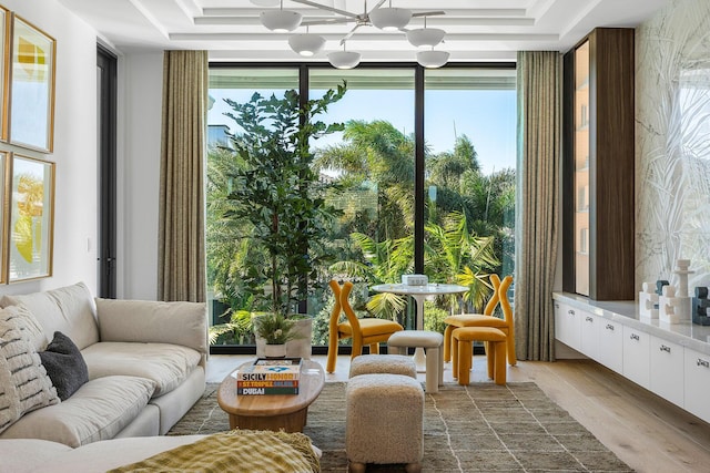 sunroom featuring a raised ceiling and an inviting chandelier