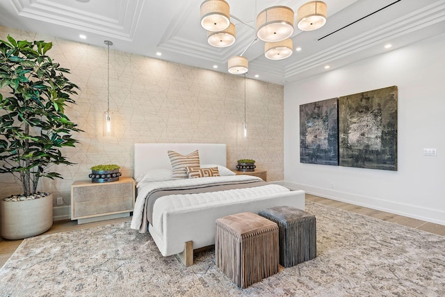 bedroom with a tray ceiling, ornamental molding, and hardwood / wood-style flooring