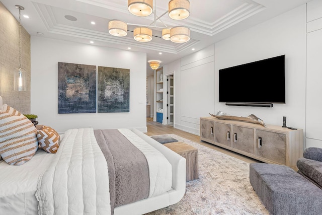 bedroom featuring wood-type flooring, crown molding, and a tray ceiling