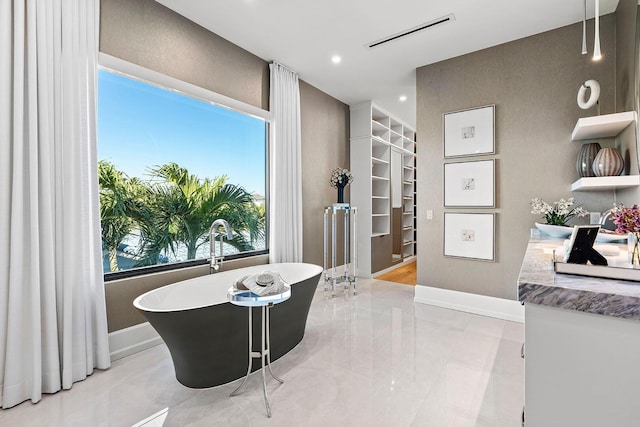 bathroom featuring a washtub and vanity