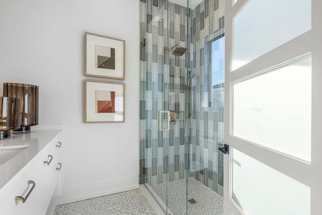 bathroom with vanity, a shower with door, and a wealth of natural light