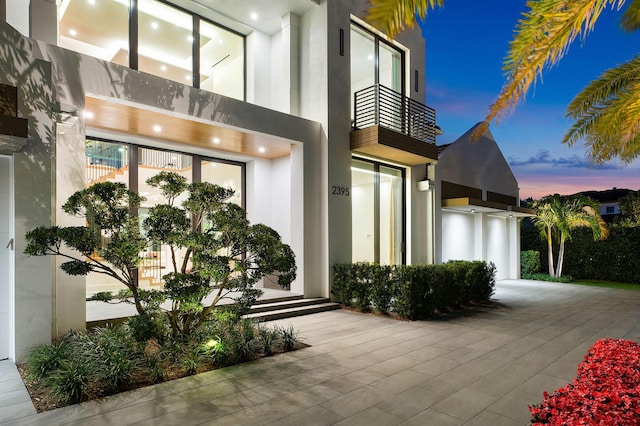 exterior entry at dusk with a balcony