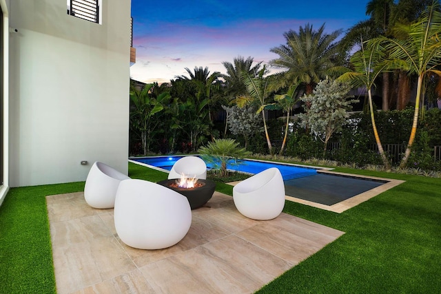 pool at dusk with a lawn and a fire pit