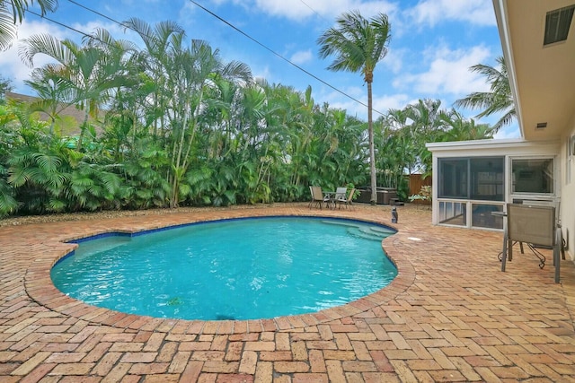 view of pool with a patio and a sunroom