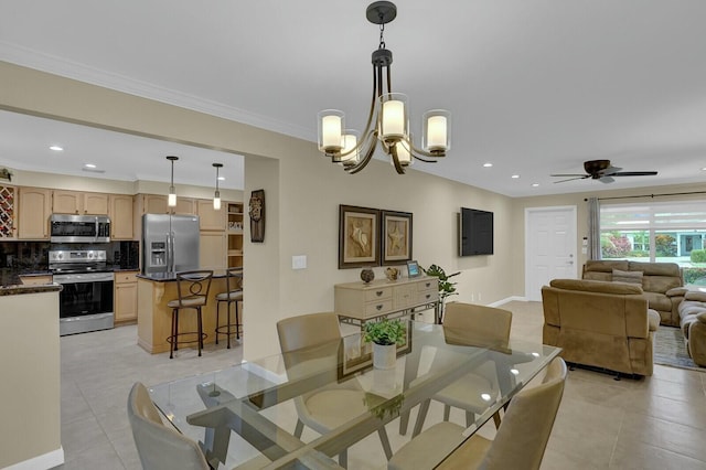 tiled dining space with ceiling fan with notable chandelier and crown molding