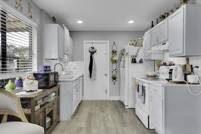 kitchen featuring white cabinetry, sink, light hardwood / wood-style flooring, white appliances, and decorative backsplash