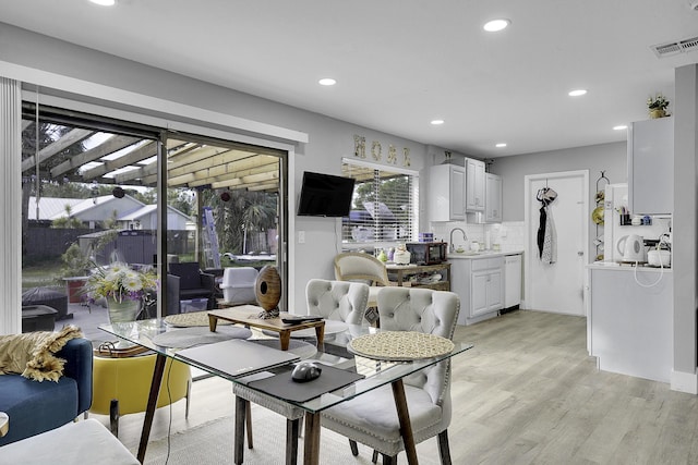 dining space with sink and light hardwood / wood-style floors