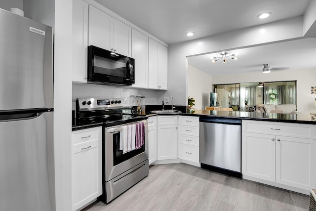 kitchen featuring white cabinets, sink, light wood-type flooring, and stainless steel appliances