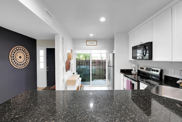 kitchen featuring white cabinets, appliances with stainless steel finishes, sink, and dark stone countertops