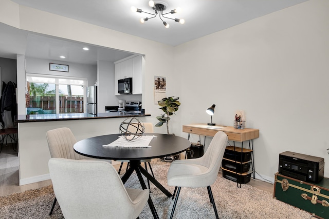 dining space with light hardwood / wood-style floors and a notable chandelier