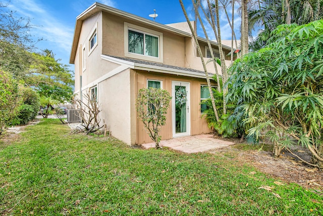 rear view of house with a yard and central AC unit