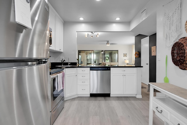 kitchen featuring white cabinetry, sink, stainless steel appliances, and light hardwood / wood-style floors