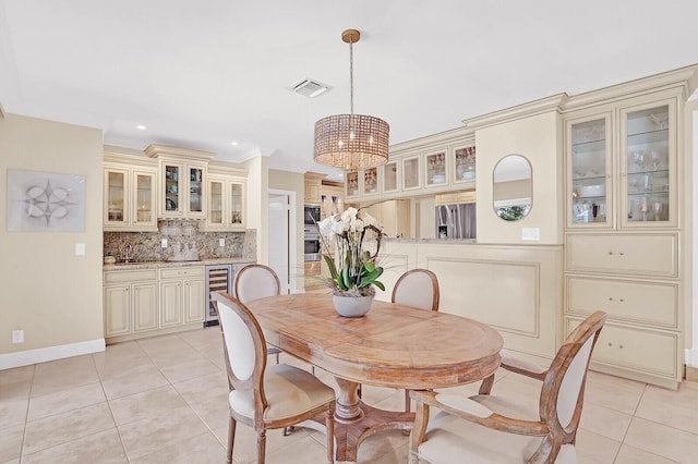 tiled dining space featuring ornamental molding and wine cooler