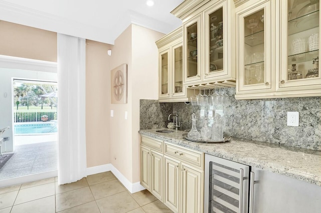 bar with light stone counters, light tile patterned floors, wine cooler, and cream cabinets