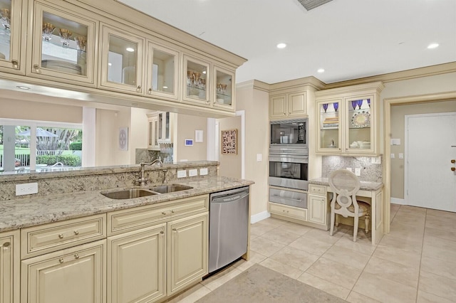 kitchen with cream cabinetry, backsplash, stainless steel appliances, and sink