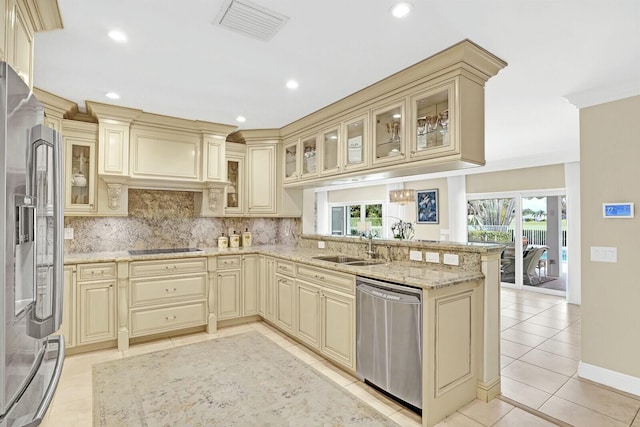 kitchen featuring cream cabinets, sink, light tile patterned flooring, kitchen peninsula, and stainless steel appliances