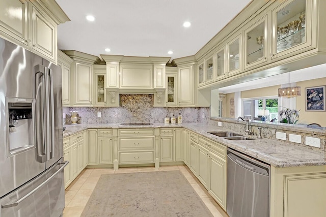 kitchen featuring cream cabinets, hanging light fixtures, sink, light tile patterned floors, and appliances with stainless steel finishes