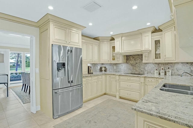 kitchen with backsplash, stainless steel fridge with ice dispenser, cream cabinets, and sink