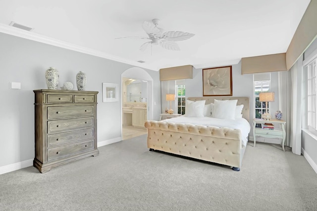 carpeted bedroom featuring ensuite bath, ceiling fan, and ornamental molding