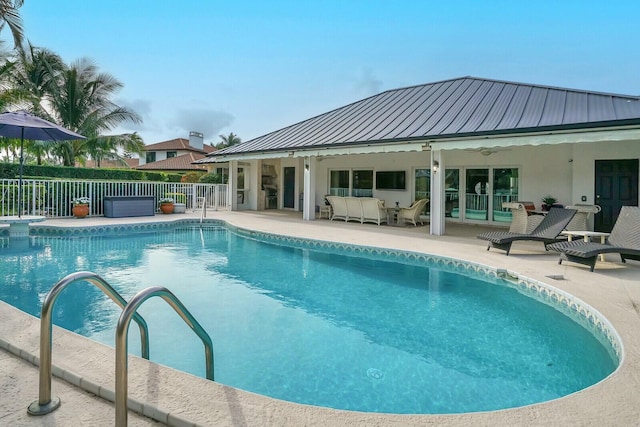 view of swimming pool featuring a hot tub and a patio area