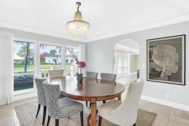 dining area with light tile patterned floors, an inviting chandelier, and ornamental molding