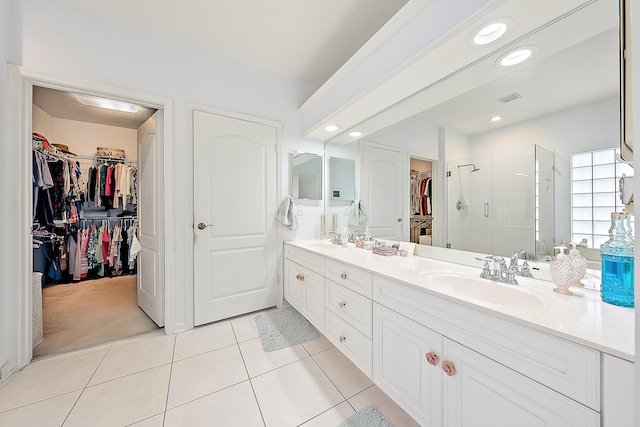 bathroom with tile patterned flooring, vanity, and a shower with shower door