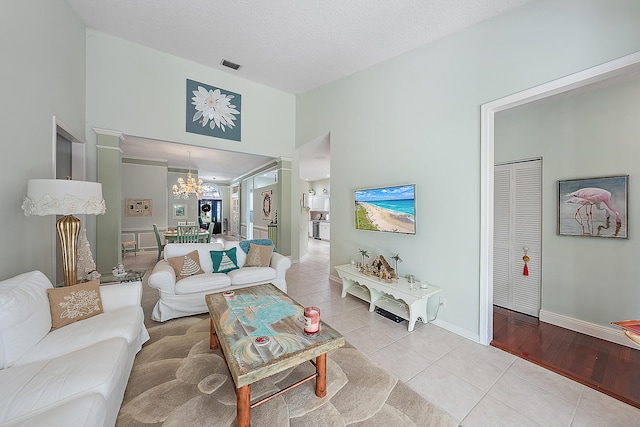 26 Princewood Ln, Palm Beach Gardens, FL 33410 - living room with light tile patterned floors, a chandelier, and baseboards
