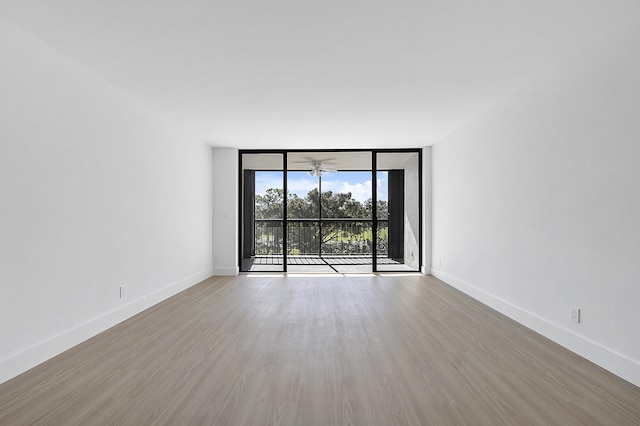 unfurnished room with light wood-type flooring and expansive windows