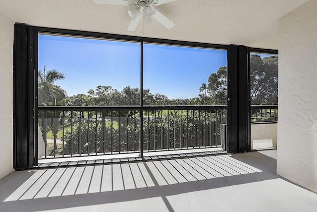 unfurnished sunroom featuring ceiling fan