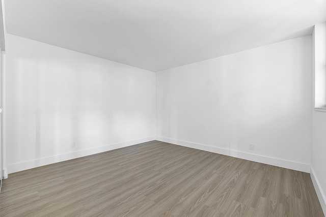 unfurnished room with hardwood / wood-style flooring