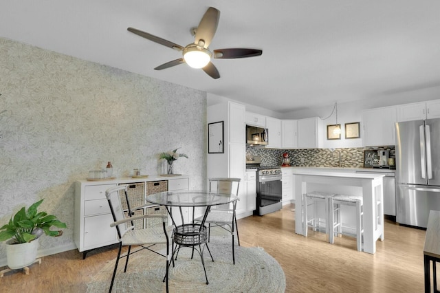 dining area with ceiling fan and light hardwood / wood-style floors